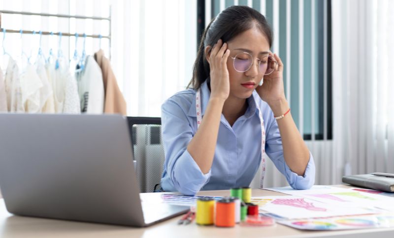 頭を抱えて悩んでいる女性