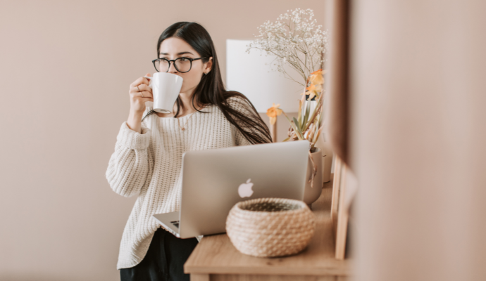 パソコンの前でコーヒーを飲む女性