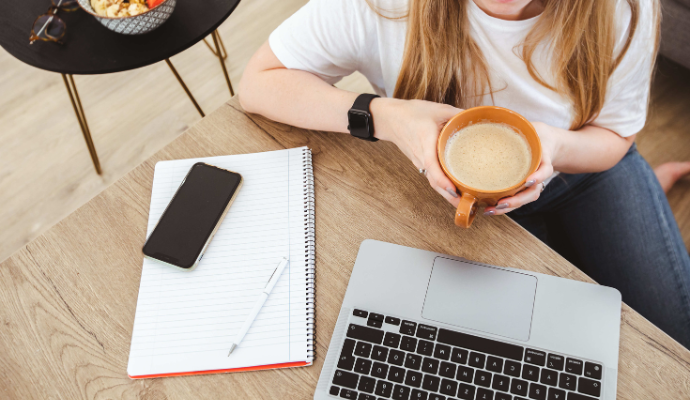 パソコンの前でコーヒーを飲む女性