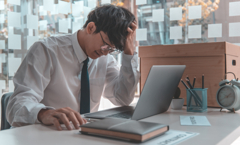 パソコンの前で頭を抱えている男性