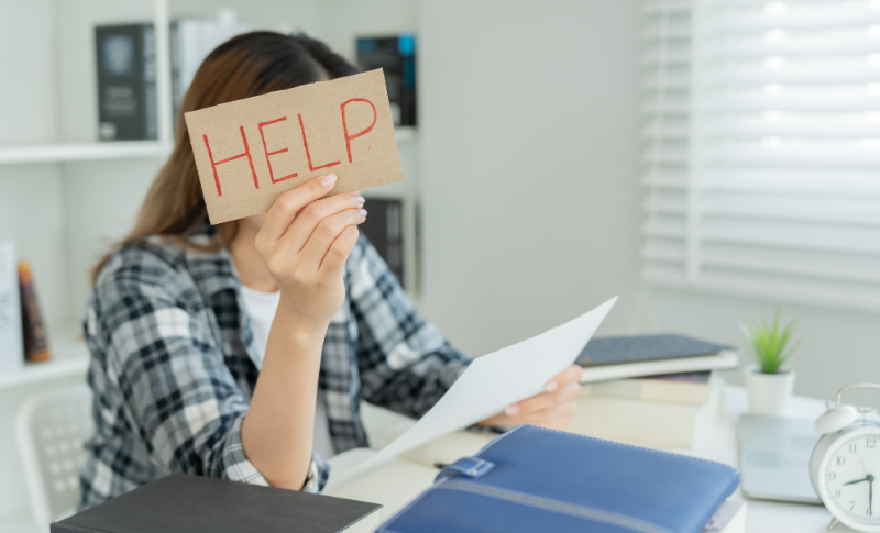 HELPのカードを掲げている女性