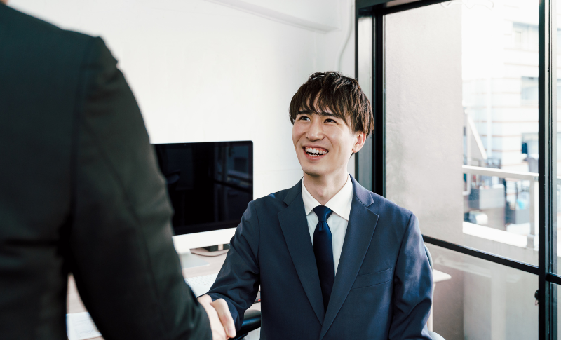 笑顔で握手をするスーツ姿の男性