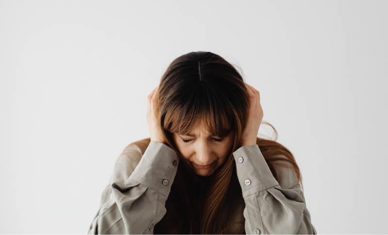 頭を抱えて悩む女性