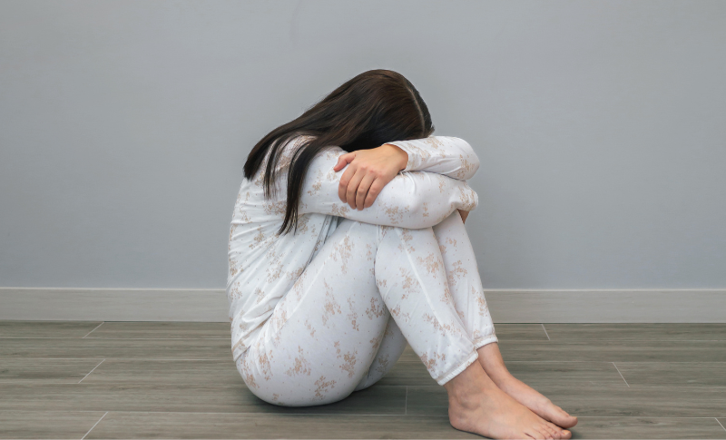 うずまって悩む女性