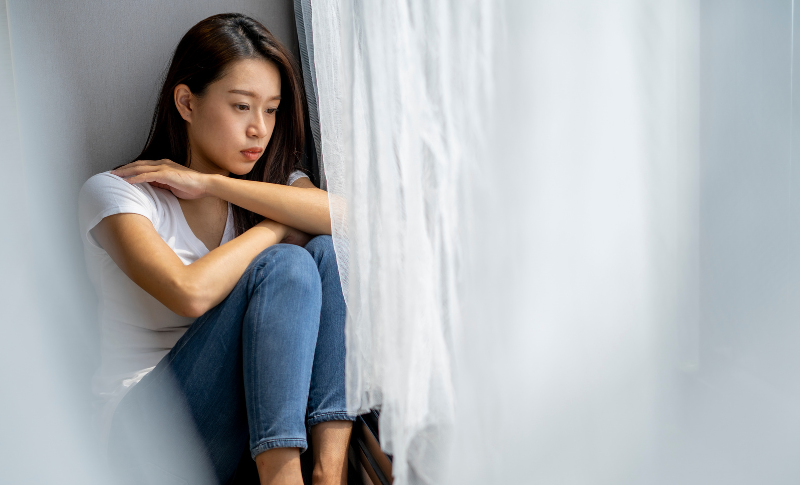 膝を抱えてうずくまる女性