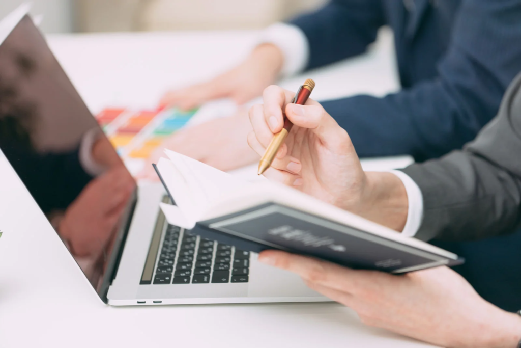 ノートとパソコンを広げて計画を立てている人