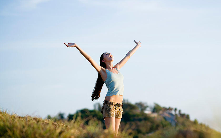 自然の中で両手を広げる女性