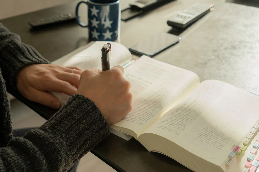 問題集を開いて、勉強する人の手元