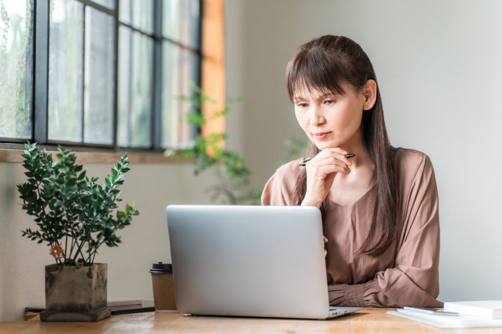 パソコンの前で考えている女性
