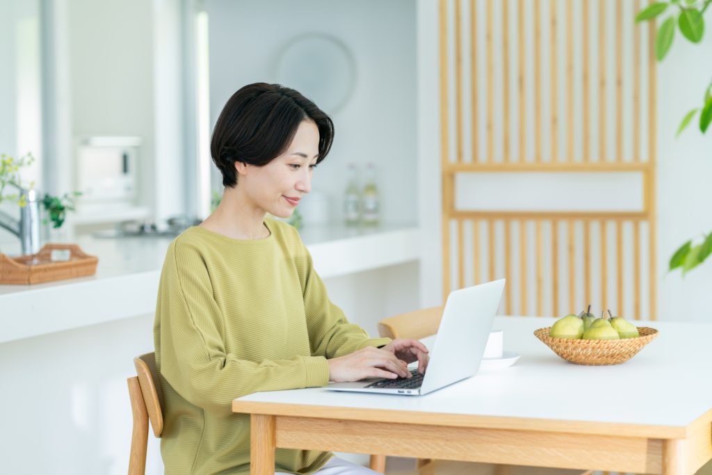 リビングでパソコンを操作している女性