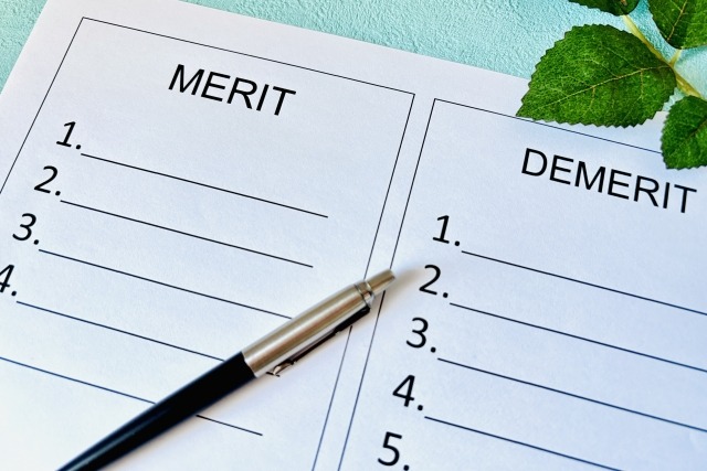 メリットとデメリットについて1ページでそれぞれ箇条書きされているA4用紙と、その上にペンが添えられている