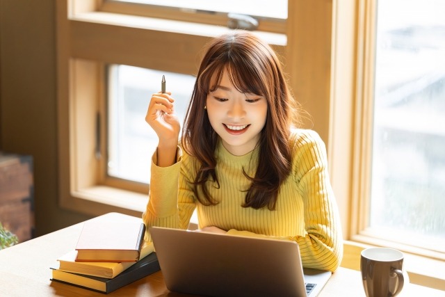 笑顔でパソコンを使って作業する女性