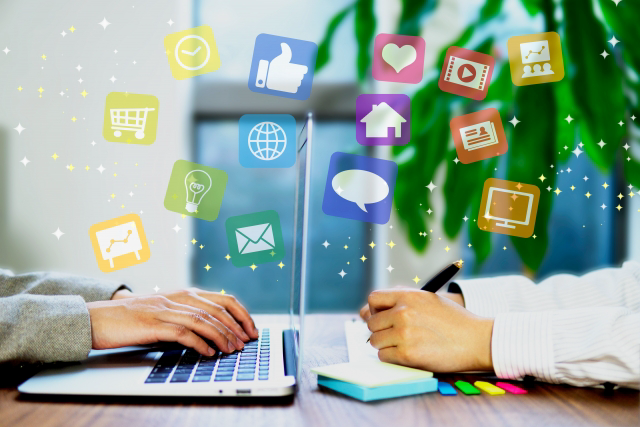 パソコンを操作する人とノートに字を書く人