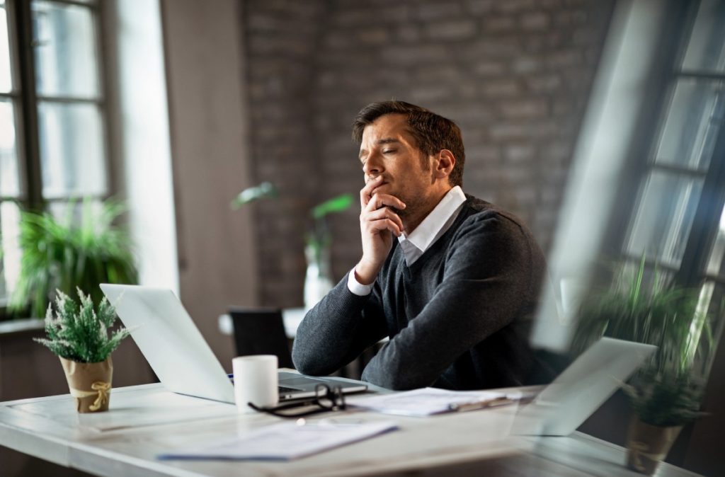 パソコンの前で悩んでいる男性