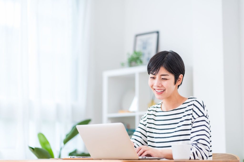 自宅でパソコンを使って情報収集に取り組む様子