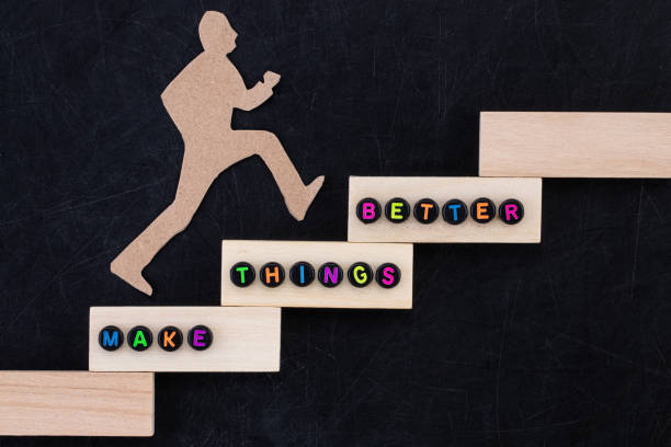 木製の積み木を階段状に並べ、その上を木製の人型が登っているような構図