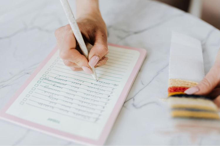 ノートにメモを取る女性