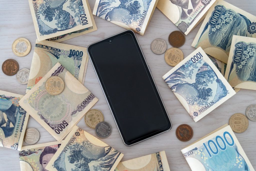スマホの周りにお金がたくさん置いてある