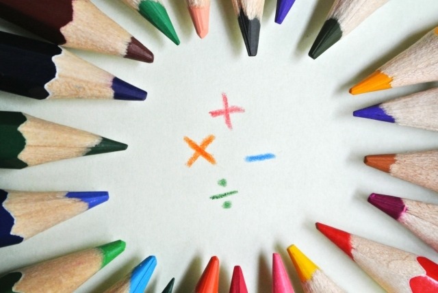 色鉛筆が中心に向かって並んでいる。中心には＋－÷×が書いてある