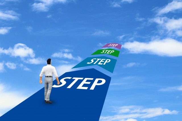 空に向かって伸びるSTEPを歩く男性