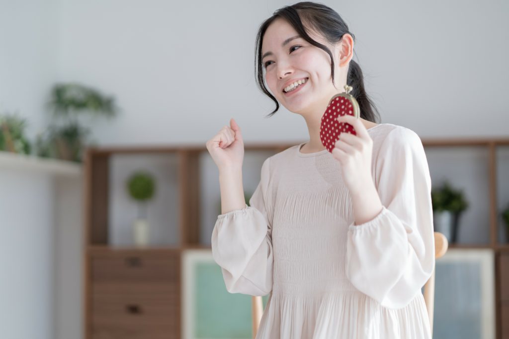お財布を手に持ちガッツポーズする女性