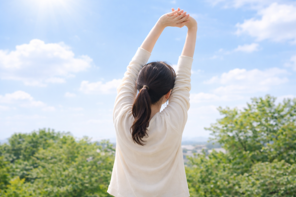 晴れた空。外で伸びをしている女性