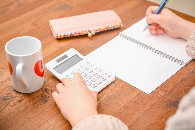 電卓を使いながら家計簿をつけている