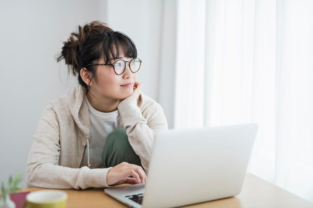ノートパソコンを操作している眼鏡の女性