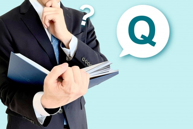 男性がファイルを持って考え事をしている。クエスチョンマークが吹き出している。