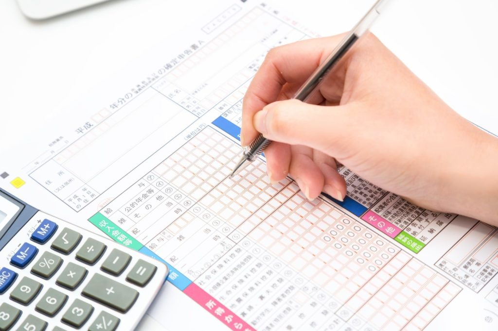 確定申告書を記入する人の手元