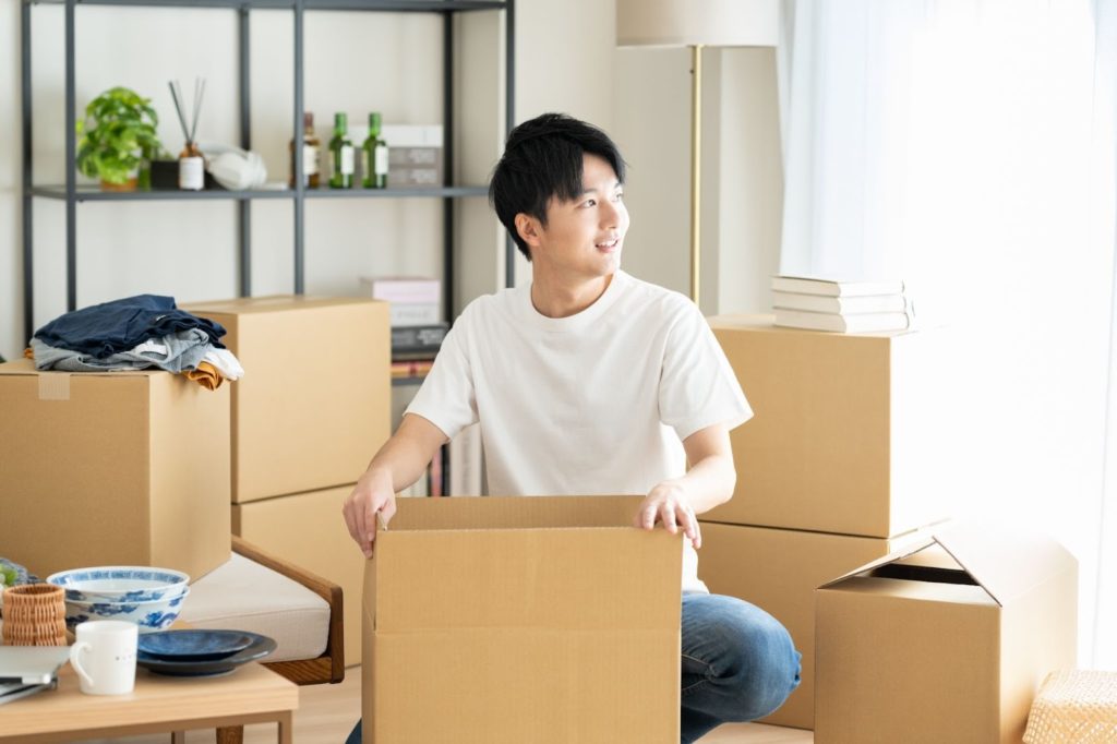 段ボールに商品を詰め込む男性