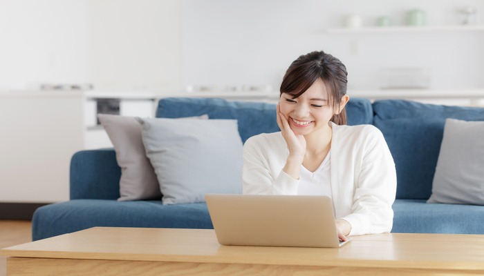 ママが笑顔でパソコンを操作している