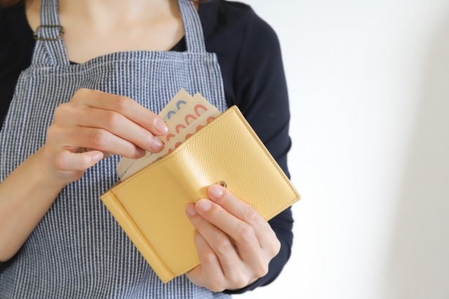 財布からお金を取り出す女性