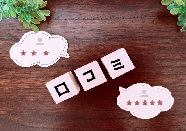 「口コミ」と書かれた木製ブロックと評価の吹き出し